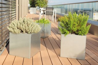 Quadratische Pflanzkästen aus Edelstahl auf einem modernen Balkon