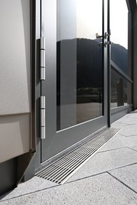 Les grilles s’intègrent esthétiquement dans l’ensemble et forment une transition élégante entre la façade et le pavage, tout en étant agréables à pratiquer pieds nus.  Photo : Richard Brink GmbH & Co. KG